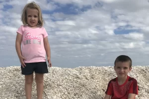 giant piles of shells dwarf these two children