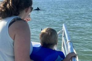 Kid in a life jacket on a dolphin tour